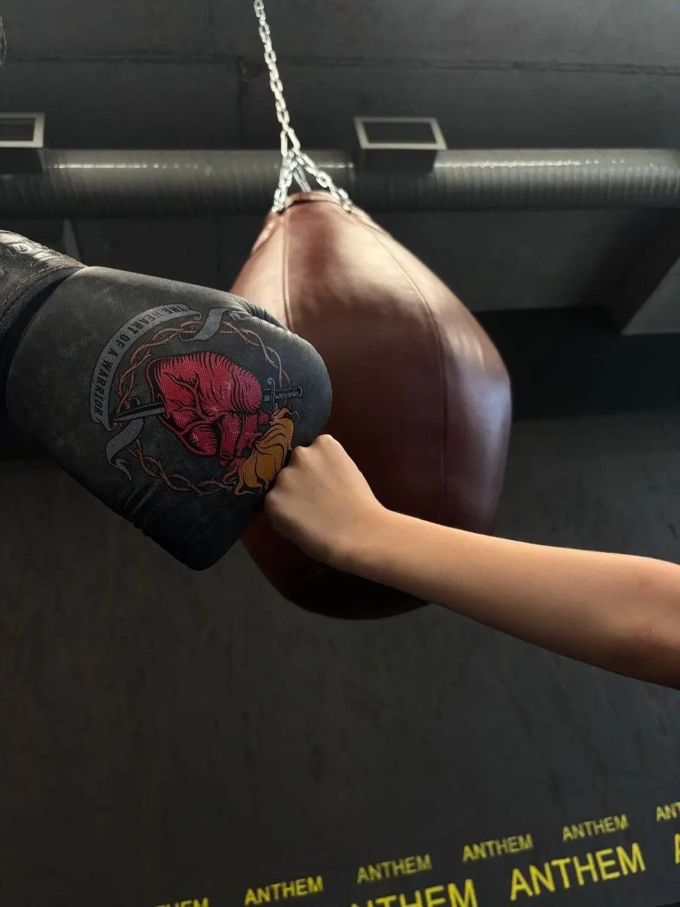 детская рука тянется к боксерской перчатке